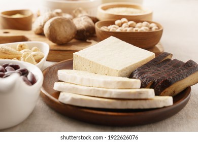 Close up of tofu or bean curd and fermented tempeh in wooden plate among other alternative sources of plant proteins for Vegan, Plant-based, Vegetarian diet. Soy products, Heart healthy food, Calcium.