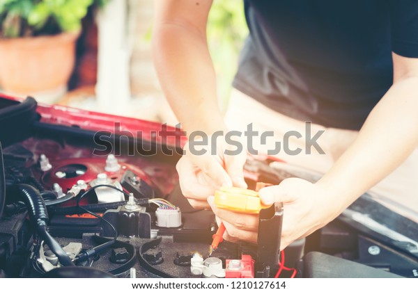 close up tool and men\
hand of mechanic car repair during investigate cause of problem\
(electric system check) or working on automobile gasoline or diesel\
engine at garage