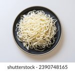 Close up and top angle view of stacked raw dried squid pieces on black dish and white floor, South Korea
