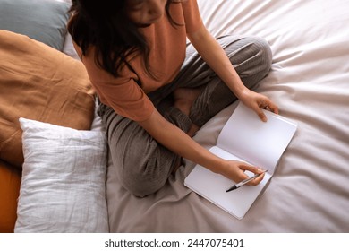 Close up of top view of asian teen female college student sitting on the bed writing on diary. Lifestyle. - Powered by Shutterstock