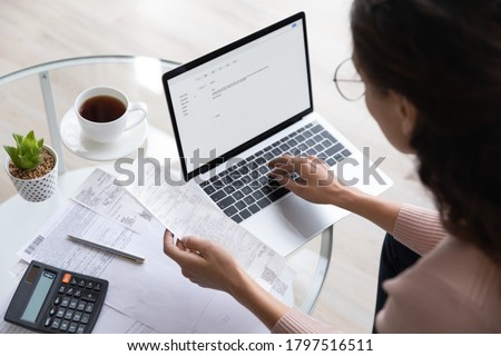 Close up top view of concentrated woman work on laptop manage family expenditures expenses using gadget, focused housewife busy calculating finances, plan budget on computer, pay bills or taxes online
