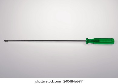 Close up top view of cross screw driver with green plastic handle against white background. Photo taken December 25th, 2023, Zurich, Switzerland.