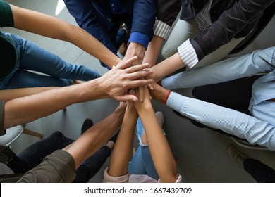 Close up top view of diverse businesspeople stack hands motivated for shared business success at briefing, multiracial colleagues engaged in teambuilding activity show unity support at office meeting - Shutterstock ID 1667439709