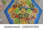 Close up top view flat lay of the popular strategic economic board game Settlers of Catan. Concept: entertainment in the family and with friends, hobbies, free time, weekends