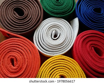 Close Up Top View, Looking Down At Brightly Coloured Coiled (rolled) Karate Belts, Martial Arts, White, Yellow, Orange, Red, Green, Blue, Brown, Status And Kyu Rank