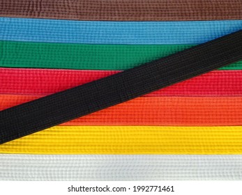 Close up top view, looking down at brightly coloured karate belts (martial arts), of various rank - Powered by Shutterstock