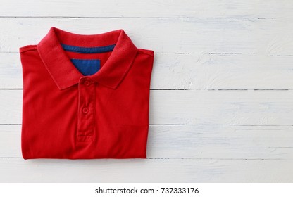 Close Up Top View Of Man Polo Shirt Put On Rustic Wooden Table Top With Blank Space Use For Texts Display