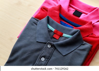 Close Up Top View Of Man Polo Shirt Put On Rustic Wooden Table Top With Blank Space Use For Texts Display