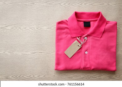 Close Up Top View Of Man Polo Shirt Put On Rustic Wooden Table Top With Blank Space Use For Texts Display