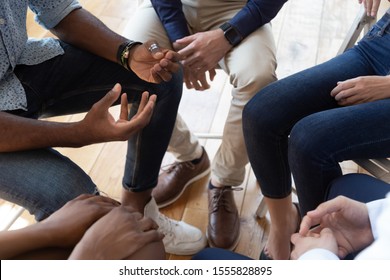 Close up top view multiracial people seated in circle talking analysing share mental problems during psychological rehab session, anonymous alcoholics association addiction treatment community concept