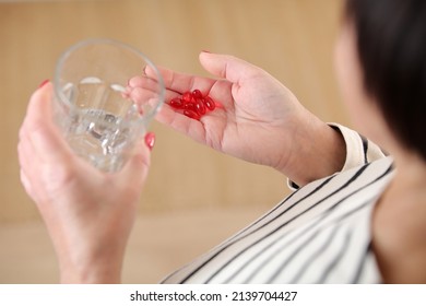 Close Up Top View Of Older Woman Hold Glass Of Water And Antibiotic Aspirin Pill Feel Unhealthy At Home, Sick Mature Female Take Daily Dose Of Supplements Or Vitamins, Elderly Healthcare Concept.