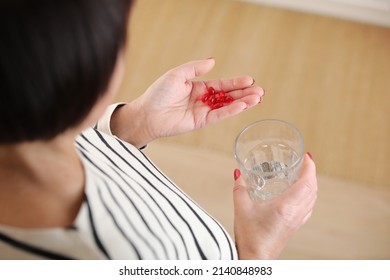 Close Up Top View Of Older Woman Hold Glass Of Water And Antibiotic Aspirin Pill Feel Unhealthy At Home, Sick Mature Female Take Daily Dose Of Supplements Or Vitamins, Elderly Healthcare Concept.