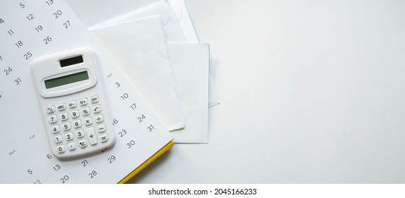 close up top view on calculator on calendar over group of invoice letter mail from bank on white background for money and debt management concept - Shutterstock ID 2045166233