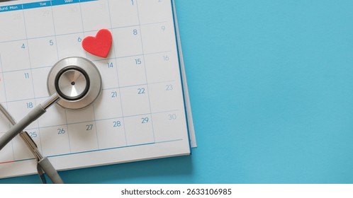close up top view on red heart symbol and stethoscope on calendar over blue background for design about ads or banner of doctor appointment and health checkup following personal lifestyle concept