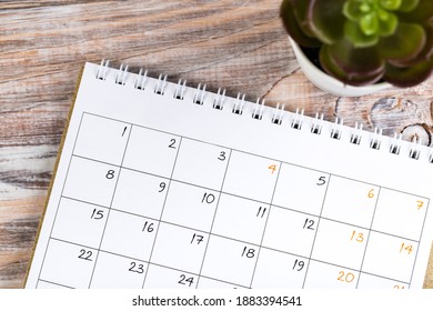 close up top view on white calendar for 2021 month schedule to make an appointment or manage schedule every day on wooden table with potted plant, succulent plant for work planning and life concept - Shutterstock ID 1883394541