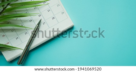 close up top view on white calendar 2026 with pencil and tropical leaves on blue color table background for planning work and life balance in holiday summer concept