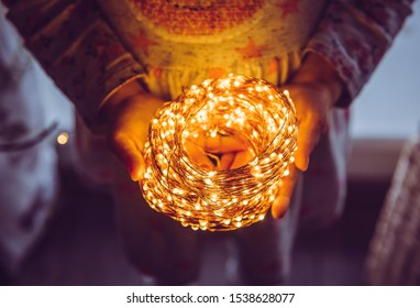 Close Up Top View Of Person Holding Roll Of Wire Micro LED String Lights In Hands.