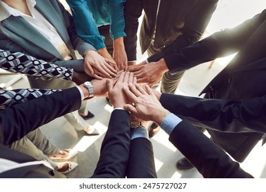 Close up top view photo of diverse business people putting their arms together. Stack of hands of a group of multiethnic company employees. The concept of unity, partnership and teamwork. - Powered by Shutterstock