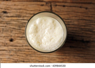 Close Up Top View Spoiled Milk In Glass On Wooden Table,bad Milk ,concept Healthy 