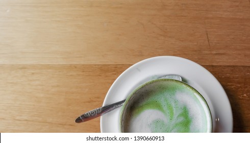 Close Up Top View White Cup Hot Green Tea With Latte On Wood Table Background And Light Shade.