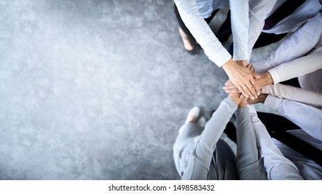Close up top view of young business people putting their hands together. Stack of hands. Unity and teamwork concept. - Shutterstock ID 1498583432
