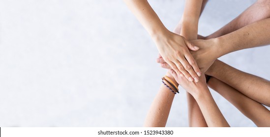 Close up top view of young business people putting their hands together. Stack of hands. Unity and teamwork concept. - Shutterstock ID 1523943380