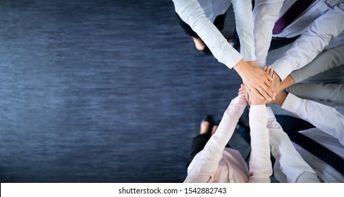 Close up top view of young business people putting their hands together. Stack of hands. Unity and teamwork concept. - Shutterstock ID 1542882743