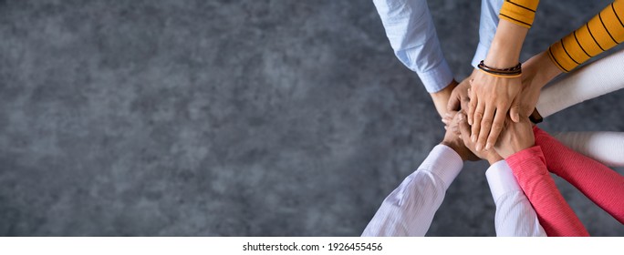 Close up top view of young business people putting their hands together. Stack of hands. Unity and teamwork concept. - Shutterstock ID 1926455456