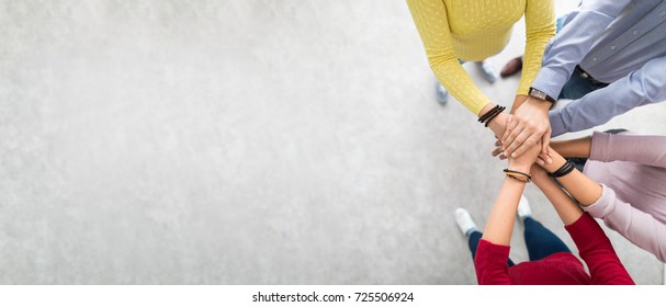Close up top view of young business people putting their hands together. Stack of hands. Unity and teamwork concept. - Shutterstock ID 725506924