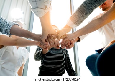 Close up top view of young and freshness energy business people putting their strong hands together. Stack of friendship hands. Unity and successful teamwork concept.