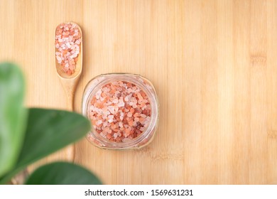 Close up topview of beautiful pinkish Himalayan salt rock in a glass jar on the wooden table. The salt is mined in Pakistan and has very rich mineral benefit for health and skin. Salt Therapy spa. - Powered by Shutterstock