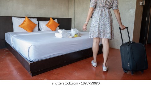 Close up of tourist woman pulling her luggage in hotel bedroom after check-in. Conceptual of travel and vacation, web banner size.