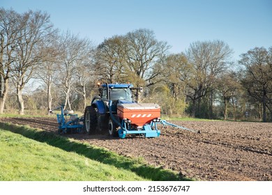 Close up of a tractor with an attached seed drill and fertilizer applicator for sowing maize in a manure prepared new maize field at Oldend in Anderen Drenthe