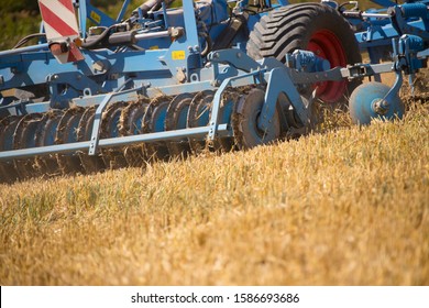 Close Up Of Tractor Ploughing Field Using Disc Plough