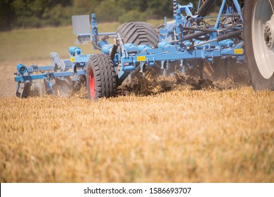 Close Up Of Tractor Ploughing Field Using Disc Plough