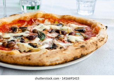 Close Up Of Traditional Capricciosa In Italian Restaurant. Front View. Italian Pizza Concept