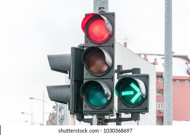 Close Up Of Traffic Light On The Crossroad With Red Light For Straight Direction But Green Arrow For Right Turn Only In The Cold Winter Day With Cloudy Sky