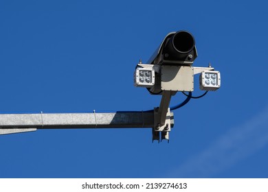 Close up of traffic security camera surveillance on the road against a blue sky background.