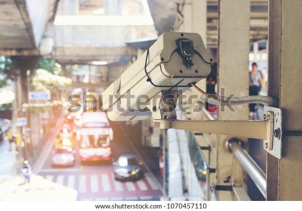 Close up of traffic security camera surveillance (CCTV)\
on the road to monitor the car traffic jam and security system\
monitoring on street road in the big city with traffic jam. vintage\
tone. 