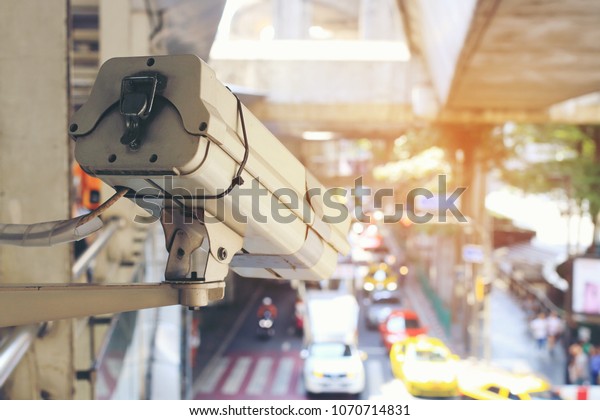 Close up of traffic security camera surveillance (CCTV)\
on the road to monitor the car traffic jam and security system\
monitoring on street road in the big city with traffic jam. vintage\
tone. 