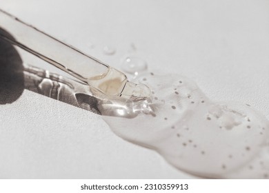 Close up of transparent serum or oil glass mock up on bottle on light background. Drops of liquid in a pipette. Concept of natural organic cosmetic and beauty, cosmetology, dermatology. - Shutterstock ID 2310359913