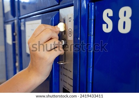 Close up of traveler hand use the coin locker (luggage office) for storing luggage while traveling around the city
