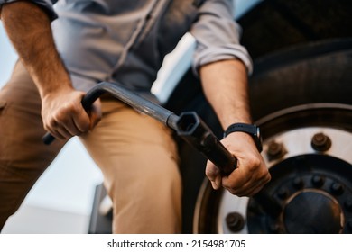 Close Up Of Truck Driver Changing Flat Tire On His Truck.