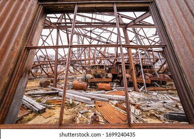 Close Up Of Trucks Inside A Run Down Airplane Hanger Abandoned By The US Air Force In World War Two. Greenland. 