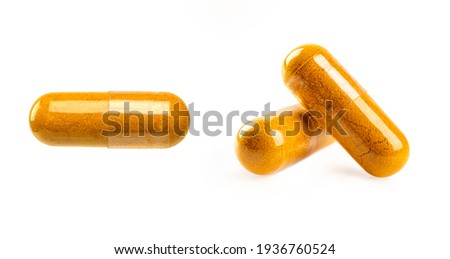 Close Turmeric capsules isolated on white background.