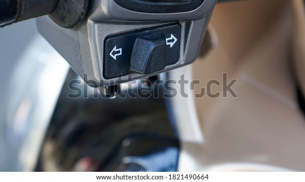 Close up of the turn signal control button on\
an automatic motorcycle
