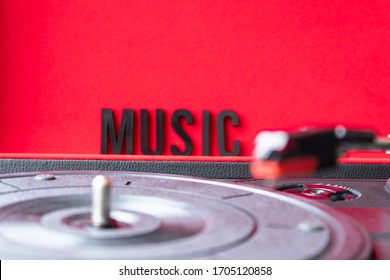 Close Up To A Turn Table Needle , Turn Table And MUSIC Lettering Word Over Red Background. Music Lovers Concept.