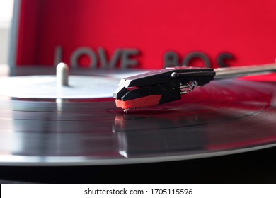 Close Up To A Turn Table Needle Playing A LP Vinyl Disc With Turn Table And I Love 80s Lettering Over Red Background. Music Lovers Concept