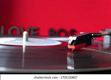 Close Up To A Turn Table Needle Playing A LP Vinyl Disc With Turn Table And I Love 80s Lettering Over Red Background. Music Lovers Concept