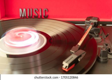 Close Up To A Turn Table Needle Playing A LP Vinyl Disc With Turn Table And MUSIC Lettering Word Over Red Background. Music Lovers Concept. Long Exposure Photography